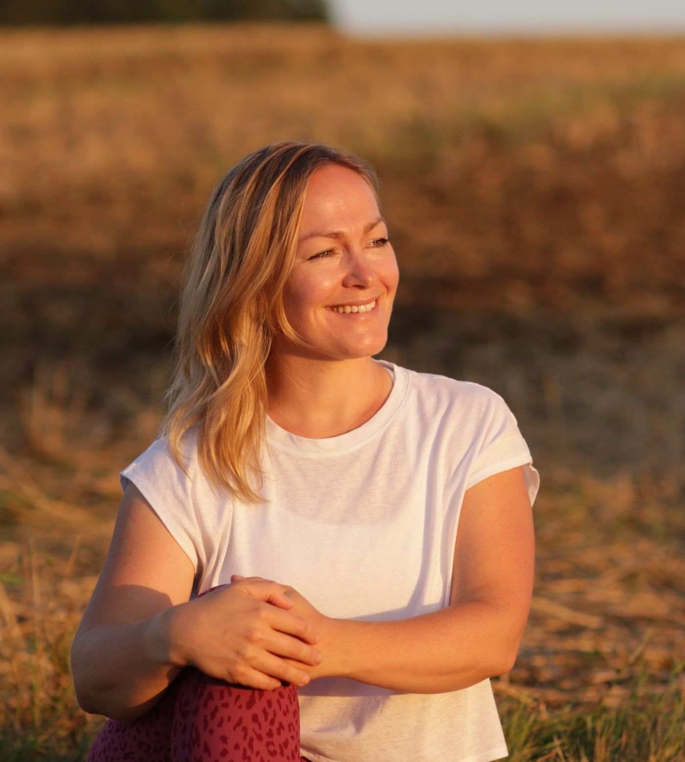Annemarie lächelt im warmen Abendlicht und schaut zur Seite, Nahaufnahme